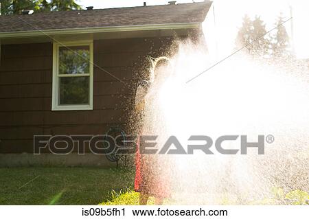Woman spraying garden with water from garden hose View Large Photo Image Stock Image - Woman spraying garden with water from garden hose. Fotosearch