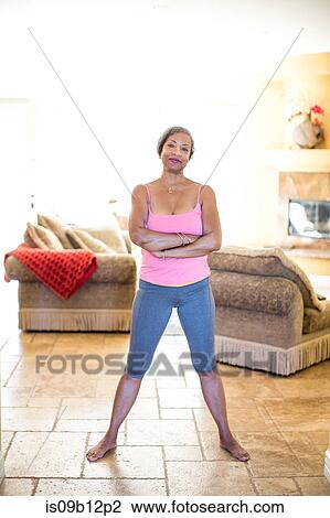 Woman standing, arms crossed, looking at camera smiling View Large Photo Image Stock Image - Woman standing, arms crossed, looking at camera smiling. Fotosearch