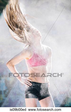 Woman standing with hands on hips throwing powder covered hair back View Large Photo Image Stock Image - Woman standing with hands on hips throwing powder covered hair back. Fotosearch