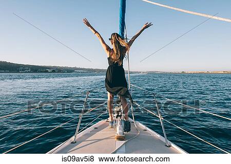 Stock Photo - Woman stretching arms on sailboat, San Diego Bay, California, USA. Fotosearch