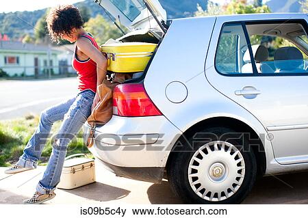 Woman struggling to push luggage into car boot View Large Photo Image Stock Photo - Woman struggling to push luggage into car boot. Fotosearch