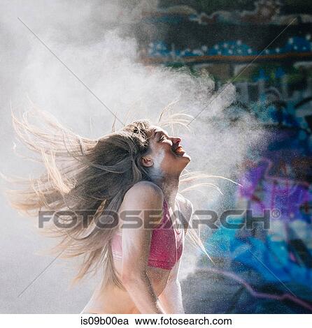 Woman throwing powder covered hair back smiling View Large Photo Image Stock Image - Woman throwing powder covered hair back smiling. Fotosearch