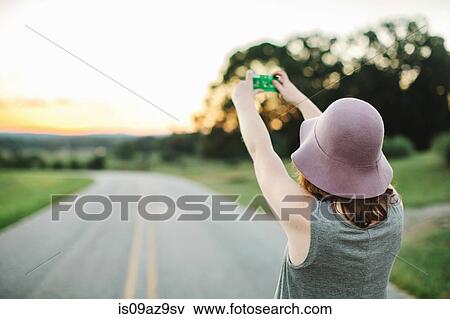 Woman using disposable camera to take photograph View Large Photo Image Stock Photo - Woman using disposable camera to take photograph. Fotosearch