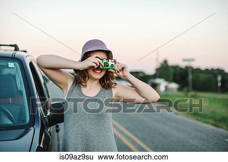 Woman using disposable camera to take photograph View Large Photo Image Stock Photograph - Woman using disposable camera to take photograph. Fotosearch