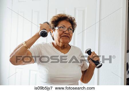 Woman using dumbbells View Large Photo Image Stock Photo - Woman using dumbbells. Fotosearch