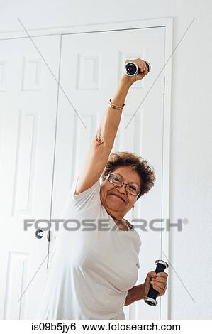 Stock Photograph - Woman using dumbbells. Fotosearch