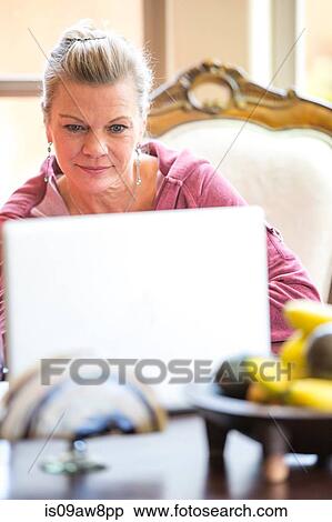 Woman using laptop at desk View Large Photo Image Stock Photography - Woman using laptop at desk. Fotosearch