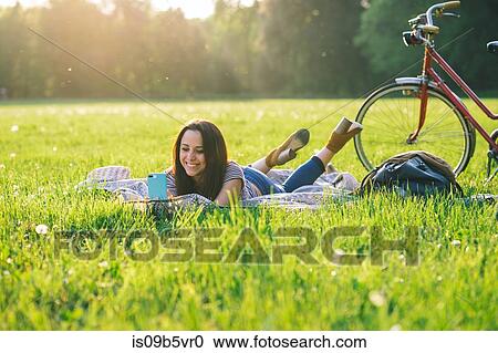 Woman using mobile phone on grass View Large Photo Image Stock Image - Woman using mobile phone on grass. Fotosearch
