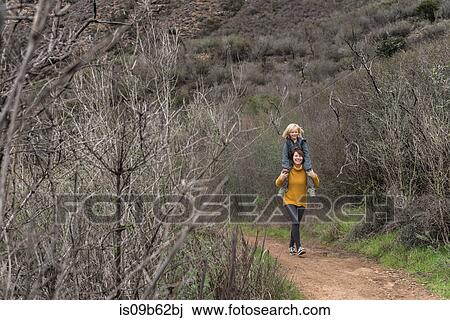 Woman walking along rural pathway, carrying son on shoulders View Large Photo Image Stock Image - Woman walking along rural pathway, carrying son on shoulders. Fotosearch