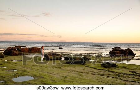 Woman watching sunset from rocky beach, Cape of Trafalgar, Spain View Large Photo Image Stock Photo - Woman watching sunset from rocky beach, Cape of Trafalgar, Spain. Fotosearch