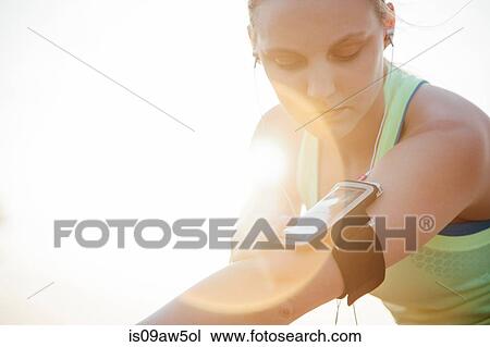 Woman wearing activity tracker on arm looking down View Large Photo Image Stock Image - Woman wearing activity tracker on arm looking down. Fotosearch