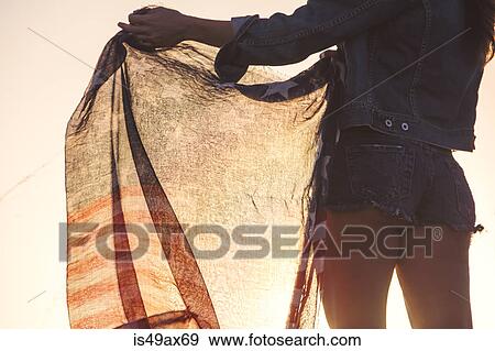 Woman wearing denim shorts, holding American flag, mid section, rear view View Large Photo Image Stock Photo - Woman wearing denim shorts, holding American flag, mid section, rear view. Fotosearch