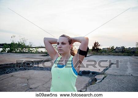 Woman wearing earbuds and activity tracker looking away View Large Photo Image Stock Photograph - Woman wearing earbuds and activity tracker looking away. Fotosearch