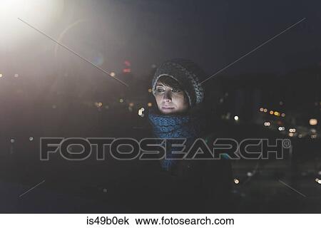 Woman wearing knit hat staring in city at night View Large Photo Image Stock Image - Woman wearing knit hat staring in city at night. Fotosearch