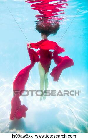Woman wearing red dress, draped in red fabric, floating underwater View Large Photo Image Stock Photo - Woman wearing red dress, draped in red fabric, floating underwater. Fotosearch