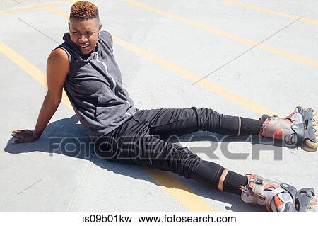 Woman wearing rollerblades sitting on floor looking away View Large Photo Image Stock Photo - Woman wearing rollerblades sitting on floor looking away. Fotosearch