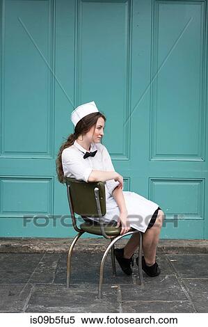 Woman wearing waitress uniform sitting in chair View Large Photo Image Stock Photography - Woman wearing waitress uniform sitting in chair. Fotosearch