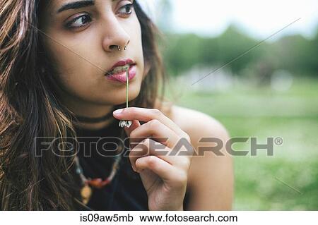 Woman with nose ring chewing grass looking away View Large Photo Image Stock Image - Woman with nose ring chewing grass looking away. Fotosearch