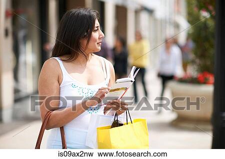 Woman with shopping bag and guide book View Large Photo Image Stock Photo - Woman with shopping bag and guide book. Fotosearch