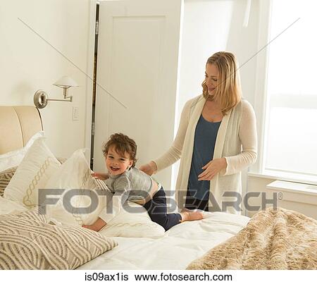 Woman with toddler son playing on bed View Large Photo Image Stock Photograph - Woman with toddler son playing on bed. Fotosearch