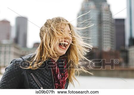 Stock Image - Woman with windswept blonde hair laughing, Boston, Massachusetts, USA. Fotosearch