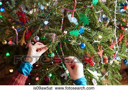 Stock Photograph - Womans hands preparing xmas decorations on xmas tree. Fotosearch