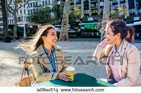 Young adult female twins talking and drinking coffee in city park View Large Photo Image Stock Photography - Young adult female twins talking and drinking coffee in city park. Fotosearch