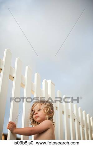 Young boy looking through wooden fence View Large Photo Image Stock Image - Young boy looking through wooden fence. Fotosearch