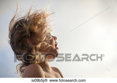 Stock Photo - Young boy outdoors, looking away, wind blowing hair,. Fotosearch