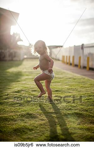 Young boy running on grass, looking over shoulder, smiling View Large Photo Image Stock Photograph - Young boy running on grass, looking over shoulder, smiling. Fotosearch