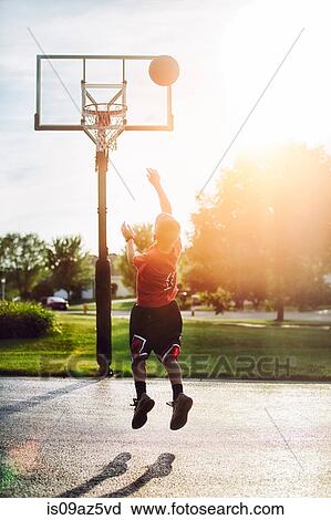 Young boy shooting basketball jump shot View Large Photo Image Stock Image - Young boy shooting basketball jump shot. Fotosearch
