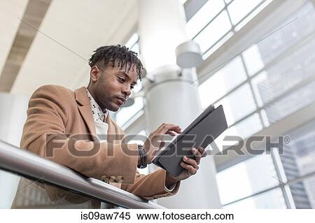 Young businessman in train station using touchscreen on digital tablet View Large Photo Image Stock Photography - Young businessman in train station using touchscreen on digital tablet. Fotosearch