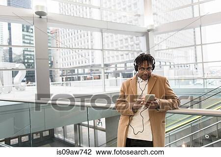 Young businessman selecting smartphone music in train station View Large Photo Image Stock Image - Young businessman selecting smartphone music in train station. Fotosearch