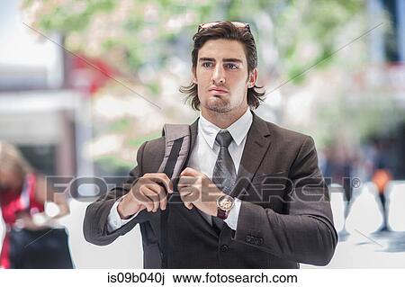 Stock Image - Young confident businessman walking in city. Fotosearch