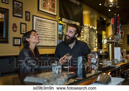 Young couple at table laughing in public house View Large Photo Image Picture - Young couple at table laughing in public house. Fotosearch