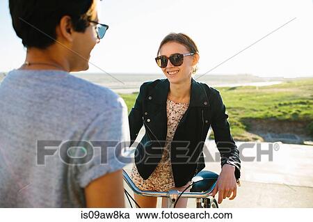 Stock Image - Young couple chatting on beach, Venice Beach, California, USA. Fotosearch