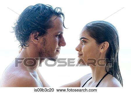 Stock Image - Young couple gazing at each other on beach, Taiba, Ceara, Brazil. Fotosearch
