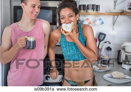 Young couple in kitchen eating open sandwich View Large Photo Image Stock Image - Young couple in kitchen eating open sandwich. Fotosearch