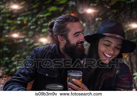 Young couple laughing in beer garden in evening, Brooklyn, New York, USA View Large Photo Image Stock Photo - Young couple laughing in beer garden in evening, Brooklyn, New York, USA. Fotosearch