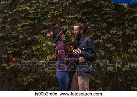 Young couple laughing in beer garden in evening, Brooklyn, New York, USA View Large Photo Image Stock Photo - Young couple laughing in beer garden in evening, Brooklyn, New York, USA. Fotosearch