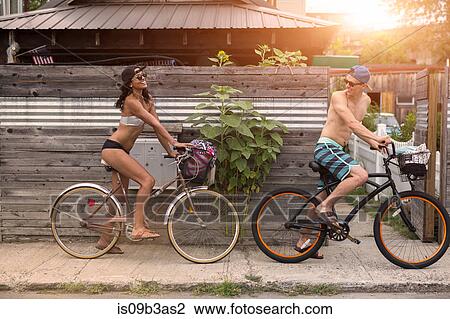 Stock Image - Young couple on bicycles, Rockaway Beach, New York State, USA. Fotosearch