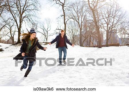 Young couple running in snowy Central Park, New York, USA View Large Photo Image Stock Photograph - Young couple running in snowy Central Park, New York, USA. Fotosearch
