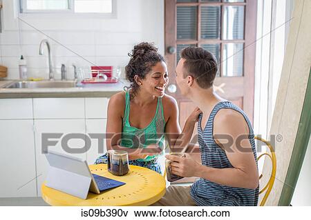 Young couple sharing coffee at kitchen table View Large Photo Image Stock Photo - Young couple sharing coffee at kitchen table. Fotosearch