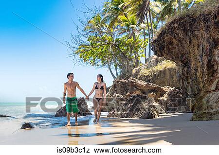 Stock Photo - Young couple strolling on beach, Taiba, Ceara, Brazil. Fotosearch
