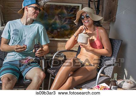 Young couple sunbathing and relaxing on porch at Rockaway Beach, New York State, USA View Large Photo Image Stock Image - Young couple sunbathing and relaxing on porch at Rockaway Beach, New York State, USA. Fotosearch