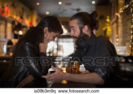 Young couple talking at table with cocktail and beer in public house View Large Photo Image Stock Photography - Young couple talking at table with cocktail and beer in public house. Fotosearch