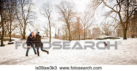Young couple with dog playing around in snowy Central Park, New York, USA View Large Photo Image Stock Image - Young couple with dog playing around in snowy Central Park, New York, USA. Fotosearch