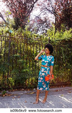 Young female fashion blogger with afro hair waiting on park sidewalk, New York, USA View Large Photo Image Stock Photo - Young female fashion blogger with afro hair waiting on park sidewalk, New York, USA. Fotosearch