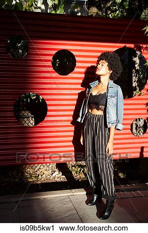 Young female fashion blogger with eyes closed by sunlit fence, New York, USA View Large Photo Image Stock Image - Young female fashion blogger with eyes closed by sunlit fence, New York, USA. Fotosearch