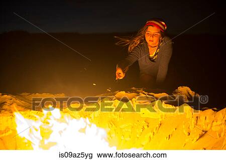 Young girl cooking food over campfire View Large Photo Image Stock Image - Young girl cooking food over campfire. Fotosearch